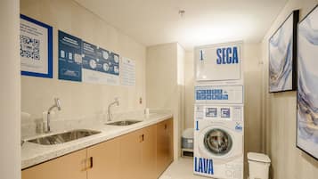 Un baño moderno con lavamanos, espejo y lavadora y secadora apiladas.