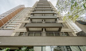 Um edifício com vários andares, varandas, fachada de tijolos e design moderno.