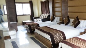 A hotel room with two beds, a ceiling fan, a window with curtains, and a tiled floor. - HOTEL SIMLA (Siliguri)