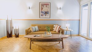 Ein modernes Wohnzimmer mit einer Couch, einem Couchtisch und einem Bild an der Wand.
