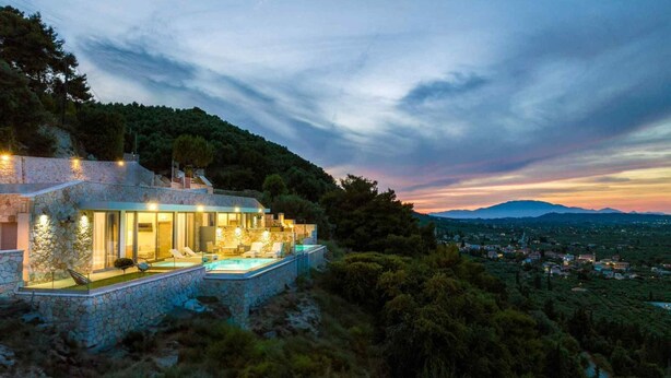 A modern villa with a stone facade, a pool, and a scenic view of the landscape. - Pietra Cave Suite with private pool (Zakynthos)