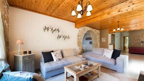 Ein geräumiges Wohnzimmer mit zwei Sofas, einem Couchtisch und einem Steinbogen.