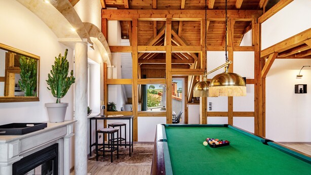 A pool table with a green felt surface, wooden beams, a fireplace, and a mirror on the wall. - Apartment 'Männerleben' with Private Terrace and Wi-Fi (Harztor)