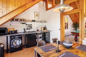Una cocina funcional con lavadora, microondas y pileta.