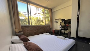 Une chambre d’hôtel avec un grand lit, un bureau et une chaise.