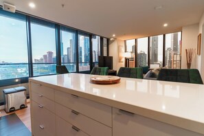A modern office space with a large desk, chairs, and a view of the cityscape through large windows. - Skyline Escape I Chic City Stay + Free Parking (Melbourne)