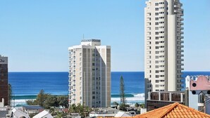 A coastal cityscape with high-rise buildings, one labeled 'Grosvenor Grosvenor,' and a view of the ocean. - Oceanview 2BR apartment in the heart of Surfers Paradise (Surfers Paradise)