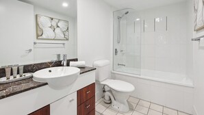 A modern bathroom with a white sink, vanity, toilet, and glass-enclosed shower. - Oceanview 2BR apartment in the heart of Surfers Paradise (Surfers Paradise)