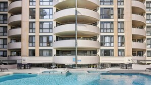Een hotel met meerdere verdiepingen, een zwembad, terras en balkons.
