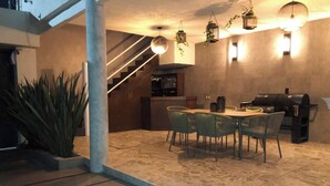 An outdoor dining area with a stone floor, a table with chairs, and a barbecue grill. - Mini depa loft (Zapopan)