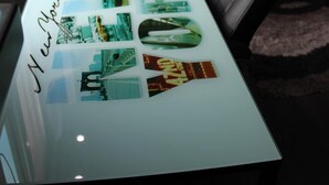 A modern office space with a glass-top table displaying various cityscape photographs. - Mini depa loft (Zapopan)