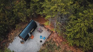 Vista aérea de una cabaña rodeada de bosque denso.