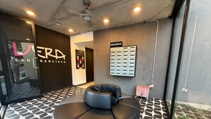 A modern interior with a circular seating area, a wall-mounted mailbox, and a visible entrance to another room.
