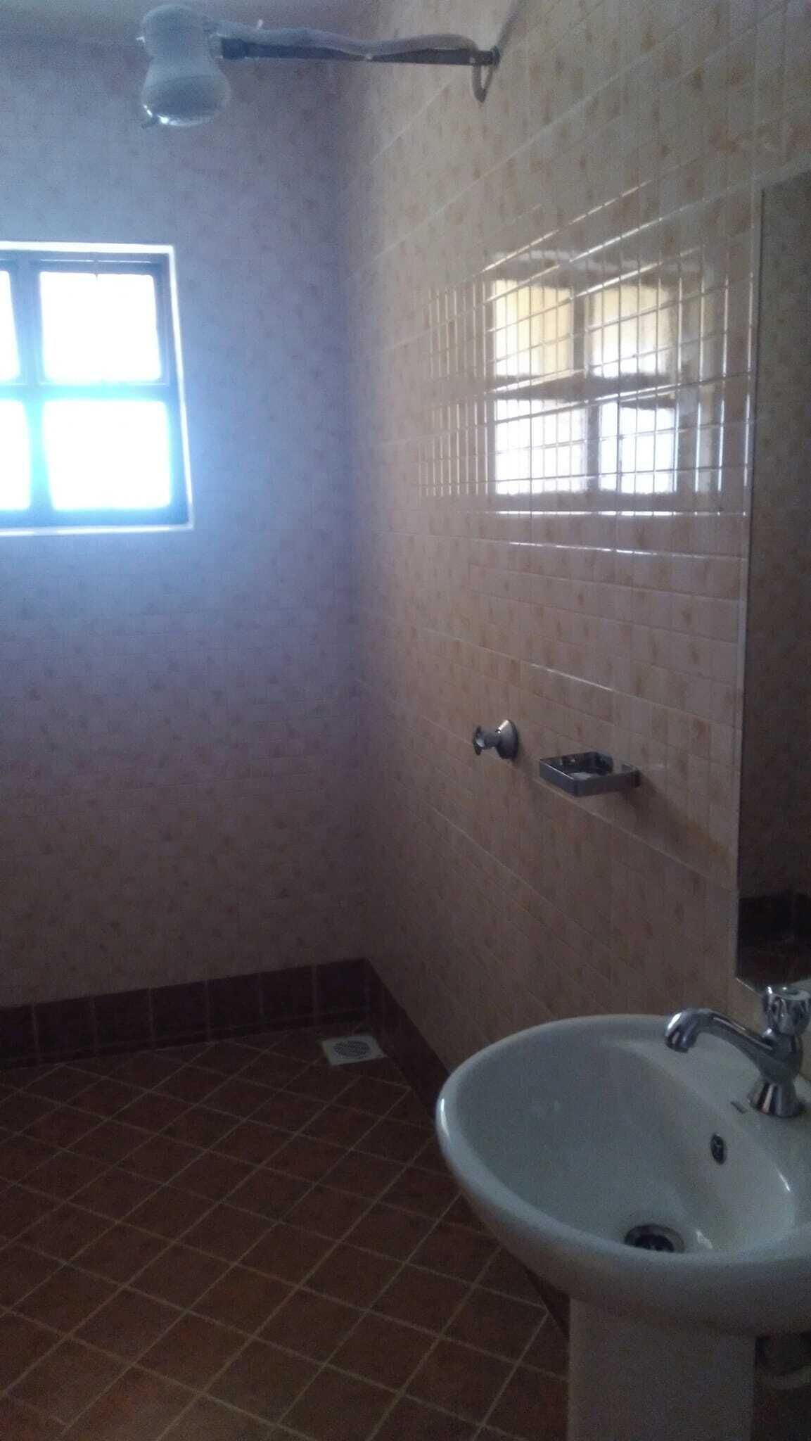 A bathroom with a sink, mirror, and window.