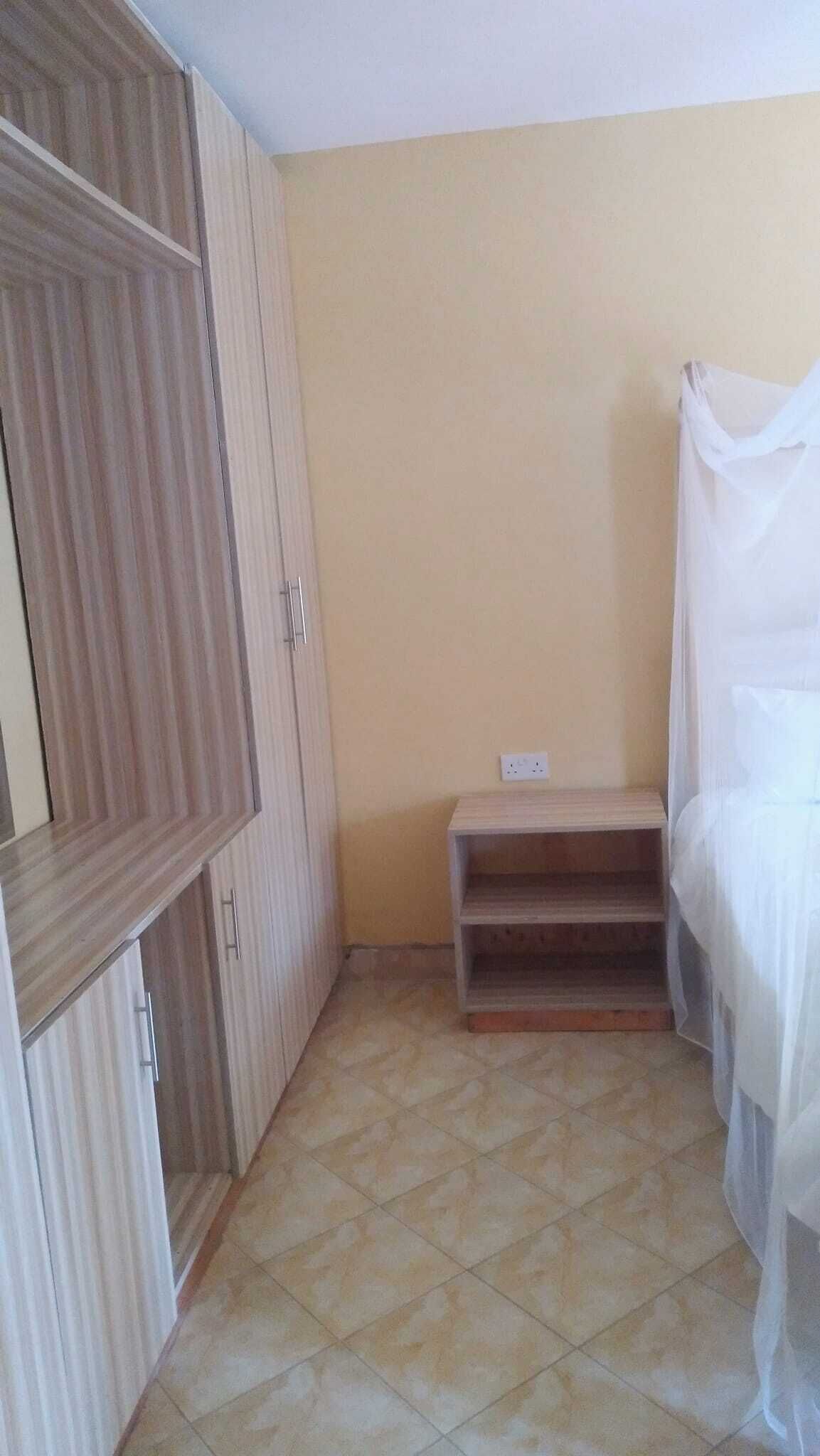 Une chambre à coucher avec un lit, une armoire et une table de chevet.