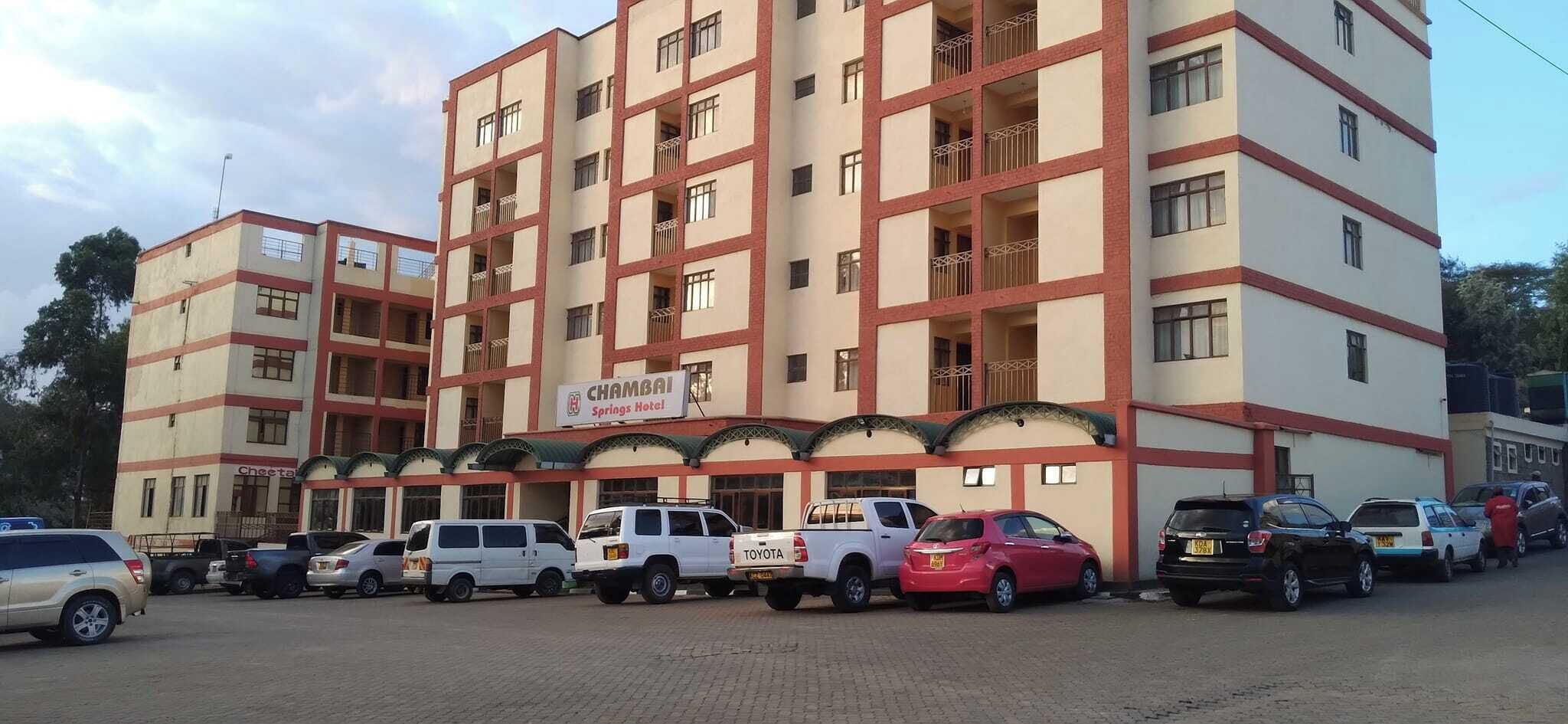 A multi-story hotel with a sign for 'Chamai Springs Hotel'.