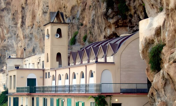 A building with a bell tower, arched windows, and a balcony with a railing.