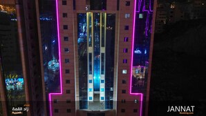 Un edificio moderno con luces de neón rosadas delineando su estructura.