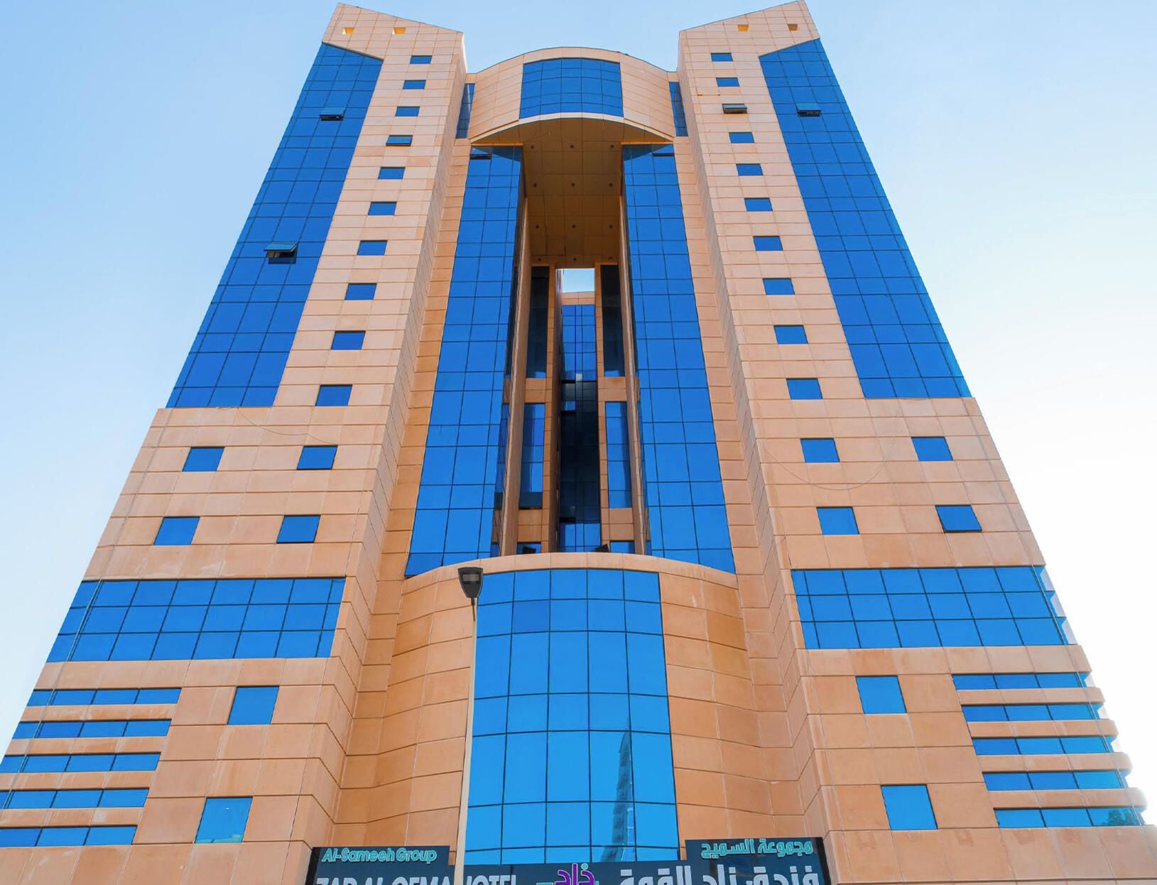 A tall hotel with a modern design, featuring a central atrium and multiple floors.
