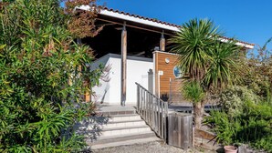 A wooden staircase leading to a white building with a tiled roof.