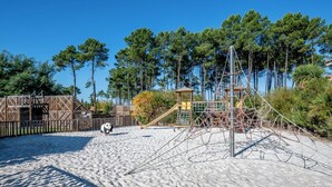 A playground with climbing structures and a wooden fence.