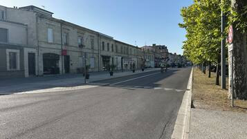 Une rue bordée d’immeubles, un panneau indiquant l’interdiction de se garer et un ciel dégagé.