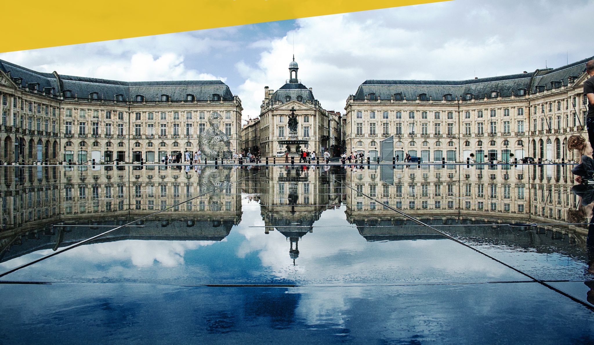 A historic building with a large central courtyard and a reflection in the water.