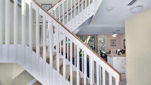 Eine Treppe mit weißen Geländern und beige gefärbten Stufen, die zu einer zweiten Etage führt.