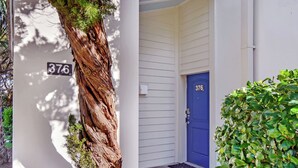 A building with a white exterior, a blue door, and a number '376' on the wall. - Villa 376 - Driftwood Cottage (Jekyll Island)