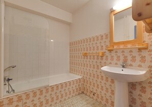 Ein Badezimmer mit einer Badewanne, einem Waschbecken und einem Spiegel.