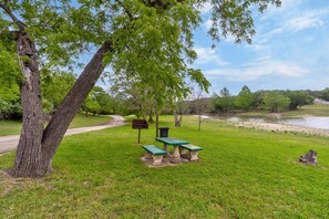 A park with a picnic table and benches, a dirt path, and a river in the background. - Moonlight Retreat, near Wedding Venue & Breweries (Dripping Springs)