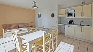 A compact living space with a kitchenette, a dining area, and a sofa.