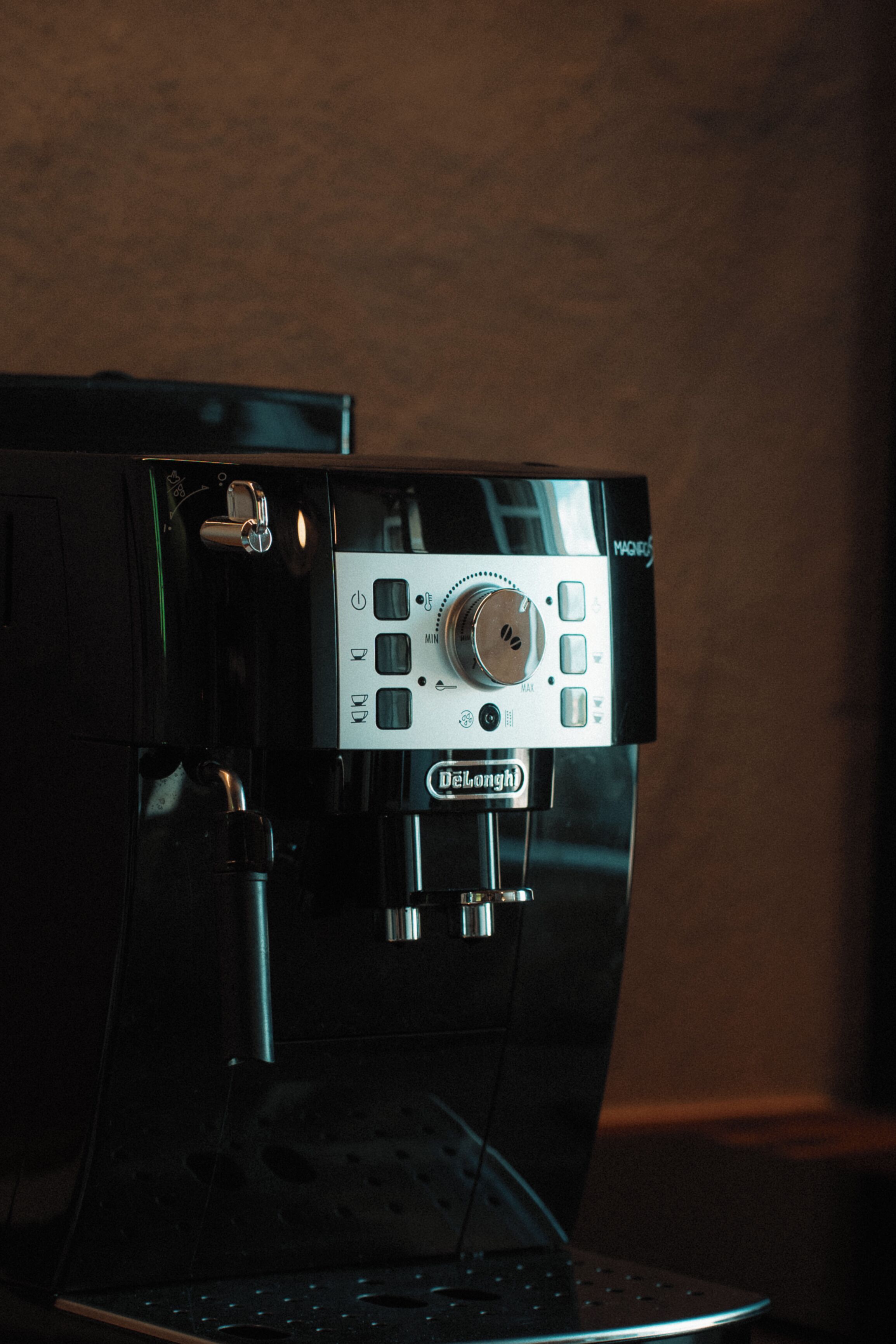 A coffee machine with a control panel, brand name, and a knob for adjusting settings.