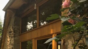 A stone building with a large wooden-framed sliding glass door.