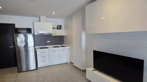 Apartamento, sacada, vista para a cidade | Cozinha privada | Geladeira, micro-ondas, cooktop, talheres/pratos/utensílios de cozinha