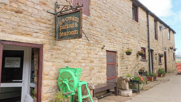 A stone building with a sign for 'ice cream parlour & tearoom'. - The Old Shippon (Macclesfield)