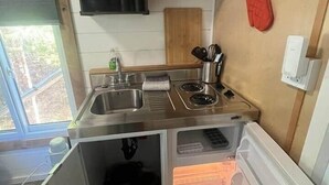 Une cuisine de taille réduite, équipée d’un évier, d’une cuisinière et de placards de rangement.