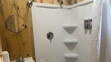 Een douche, handdoeken, zeep, shampoo