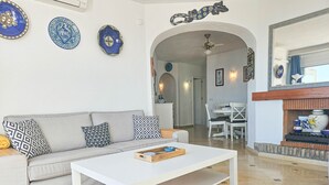 A living room with a sofa, coffee table, and decorative plates on the wall. - Seaview apartment in El Porton Calahonda (Sitio de Calahonda)