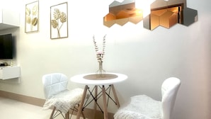 Zona pranzo moderna con un tavolo rotondo, due sedie e decorazioni a parete.