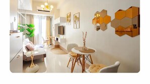 Un soggiorno moderno con un divano, un tavolino da caffè, poltrone, una TV e un elemento decorativo a parete.
