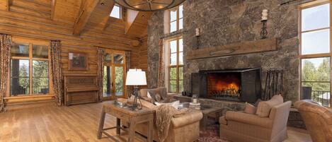 Un salón amplio con chimenea, muebles de madera y ventanas grandes.