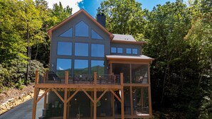 A two-story wooden house with large windows and a balcony. - Spacious 5-bedroom house in Montreat with stunning views, spa, fitness room (Black Mountain)