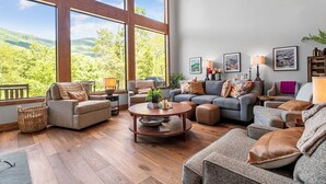 A spacious living room with large windows, a fireplace, and a cozy seating area. - Spacious 5-bedroom house in Montreat with stunning views, spa, fitness room (Black Mountain)
