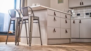 Eine moderne Küche mit zwei Barhocker, einer Arbeitsplatte und Schränken.
