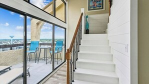 A staircase leading to a balcony with a view of the city.
