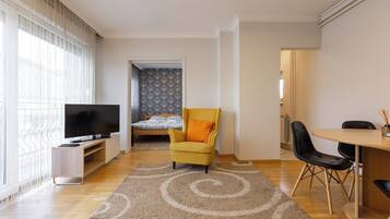 Departamento, balcón, vista a la ciudad | Área de sala de estar | Smart TV de 42 pulgadas con canales por cable