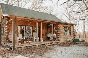 A log cabin with a porch, Christmas tree, and outdoor seating. - Unique Emerald Gabel Cabin (Salem)