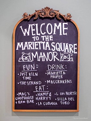 A welcome sign for Marietta Square Manor, listing fun activities, drinks, and dining options. - The Marietta Square Manor (Marietta)