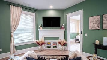 A living room with a fireplace, a sofa, and a television.